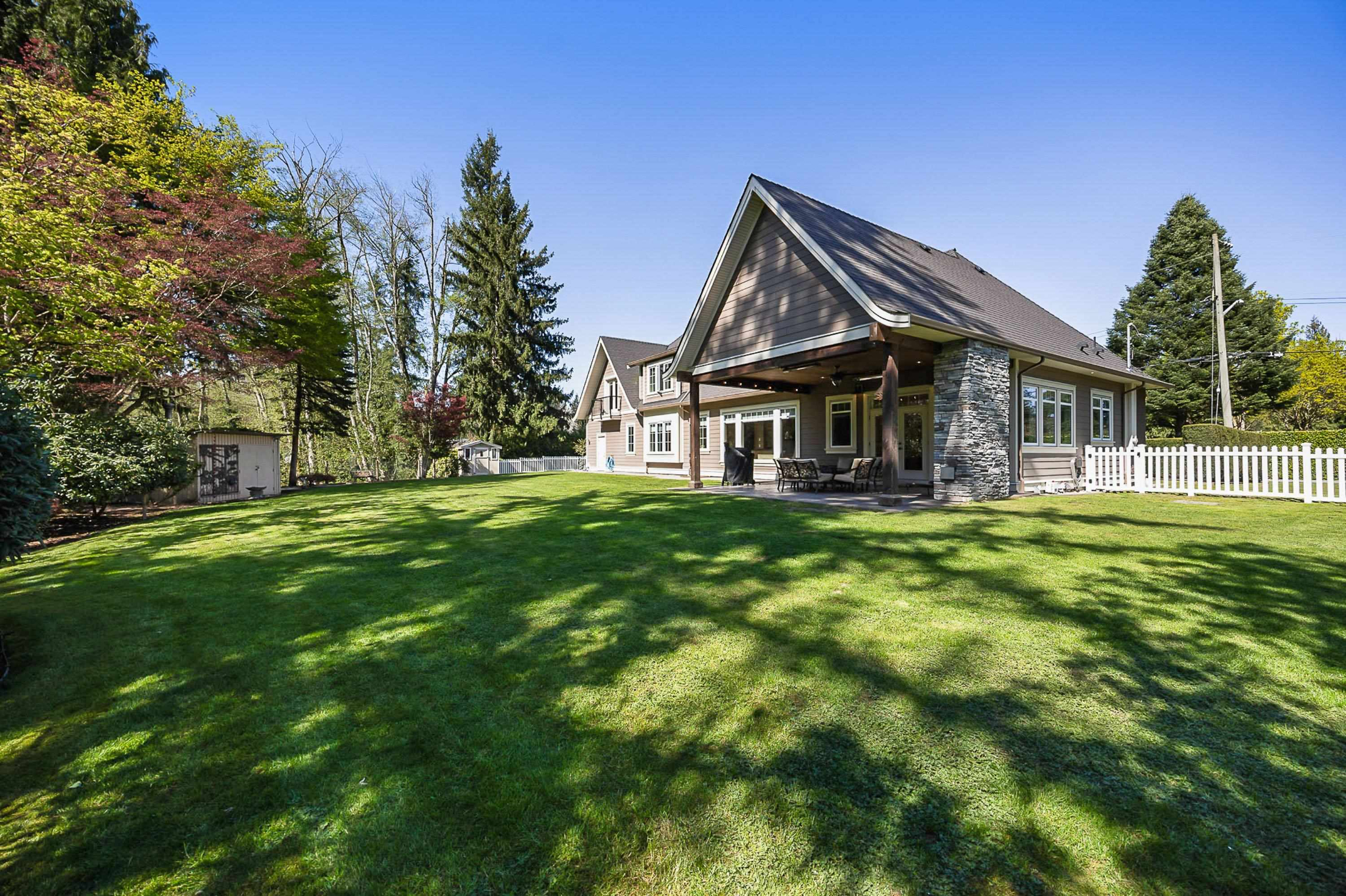Rear view of house featuring a fenced backyard, a storage shed, an outbuilding, a patio and lawn
