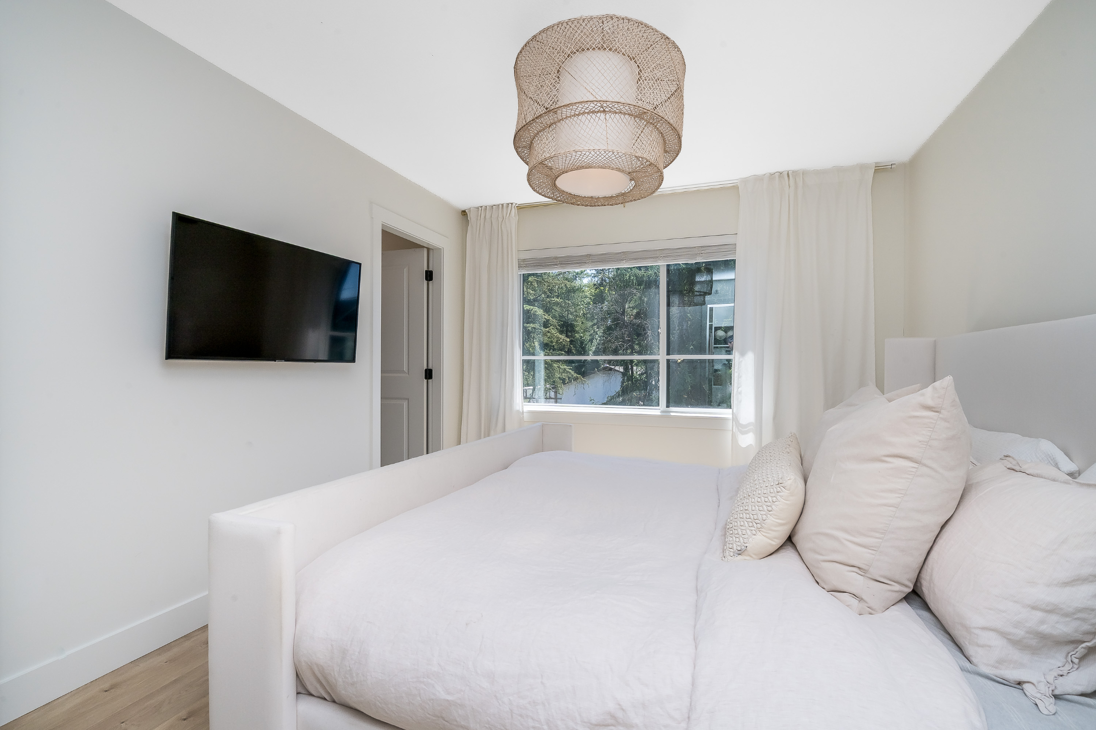 Spacious living room with sectional sofa, coffee table, and large window in Willoughby townhome.