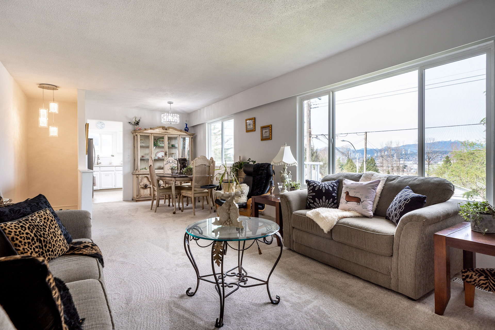 Living room featuring lght carpet, a mountain view, and a textured ceiling