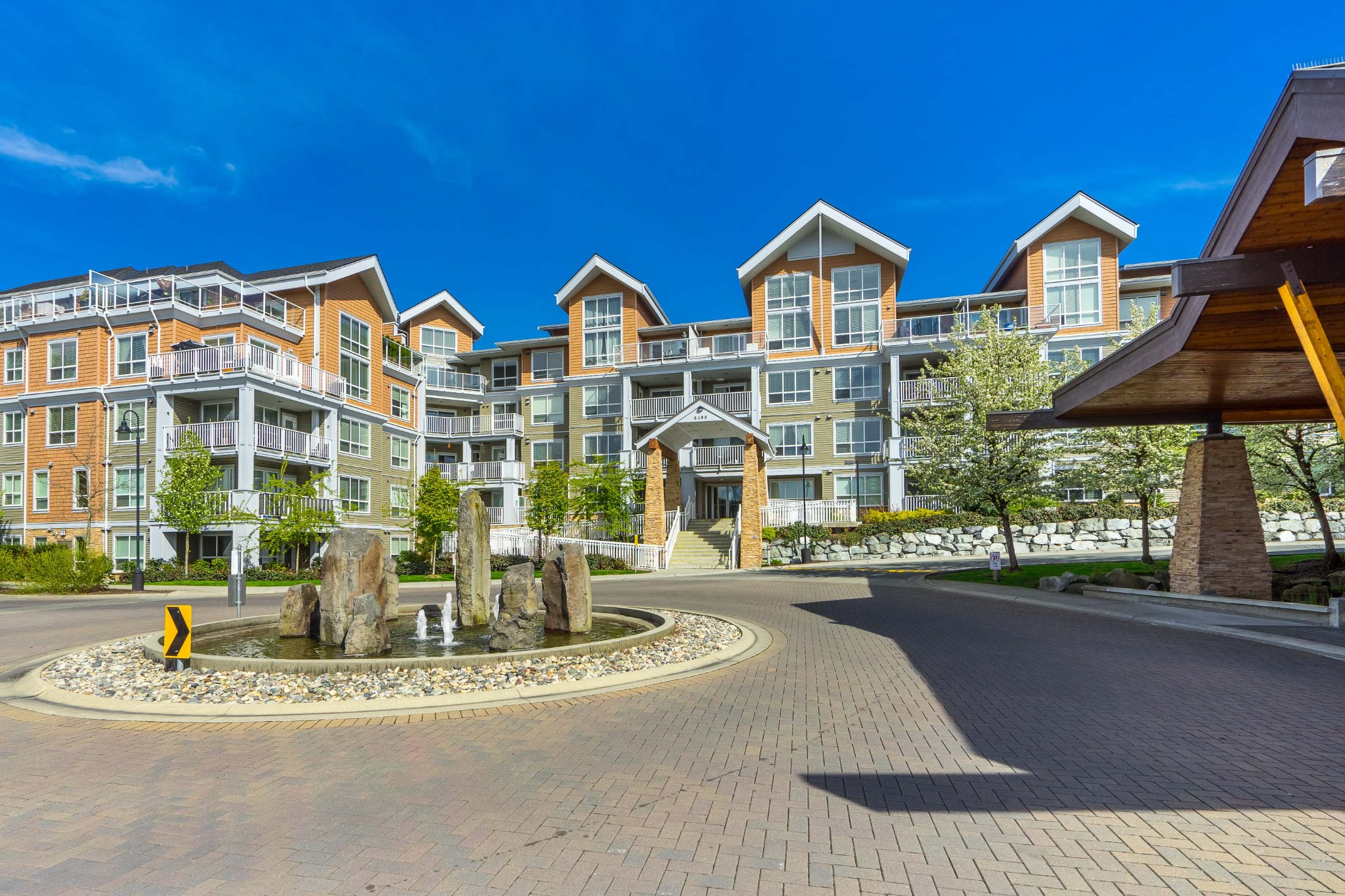 Modern condo building with stone fountain entrance.