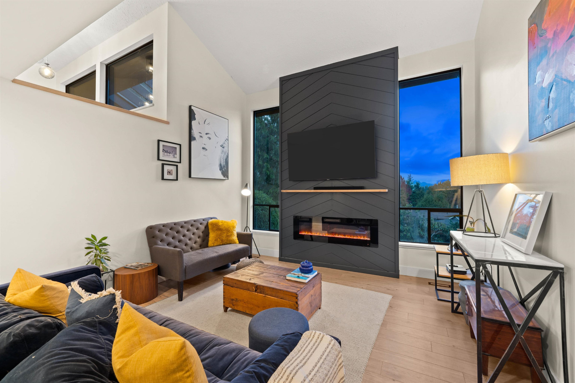 Living area featuring baseboards, a large fireplace, wood finishes, and vaulted ceiling