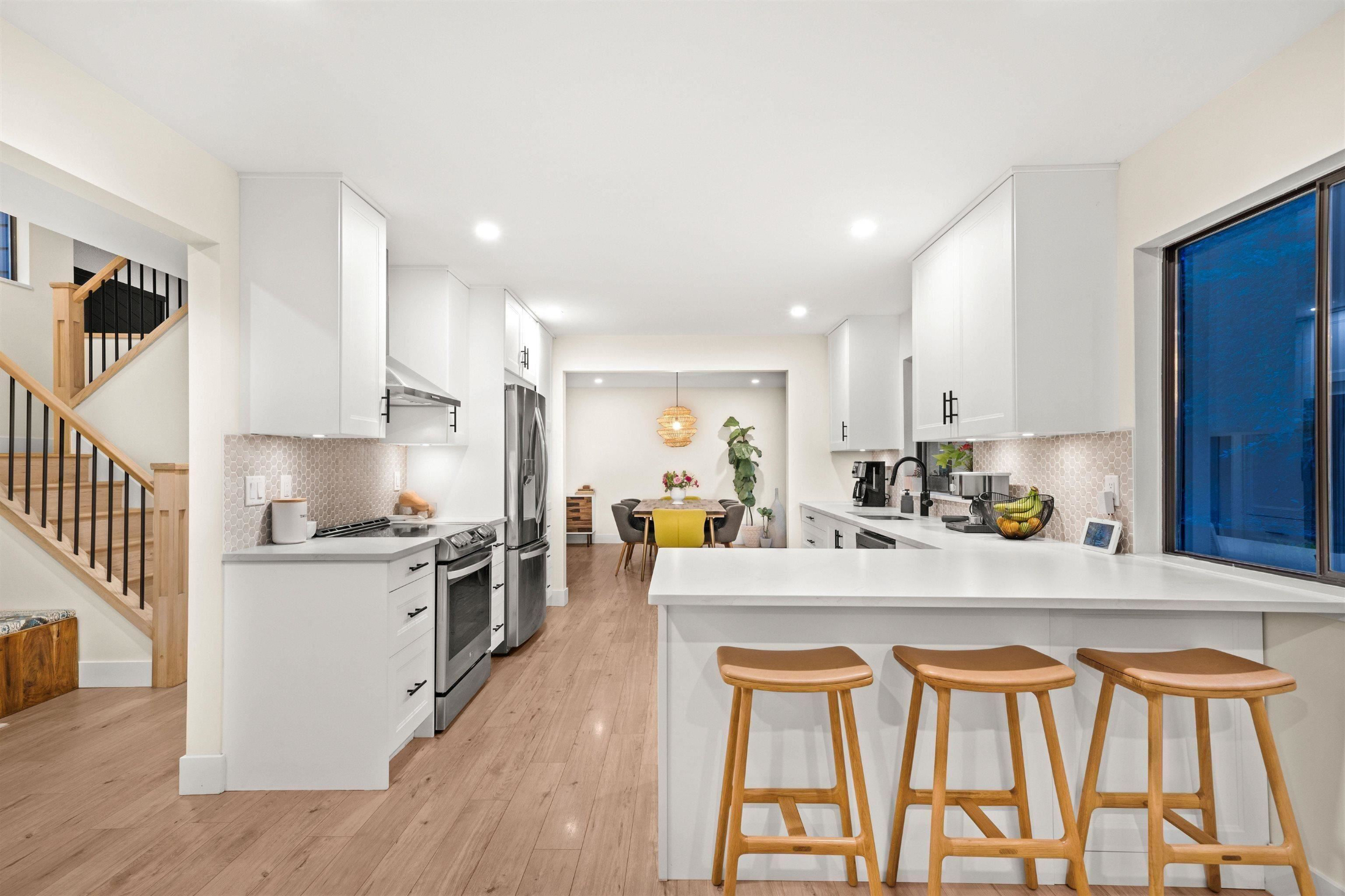 Kitchen with stainless steel appliances, a kitchen bar, light countertops, and recessed lighting